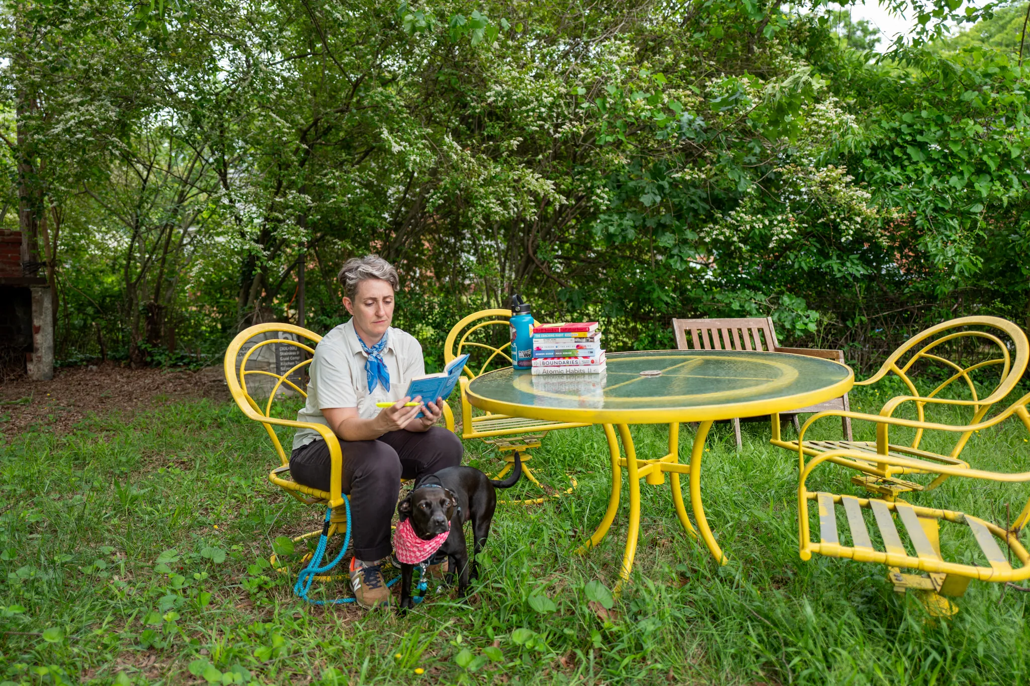 photo of a woman and her dog in the backyard at a table