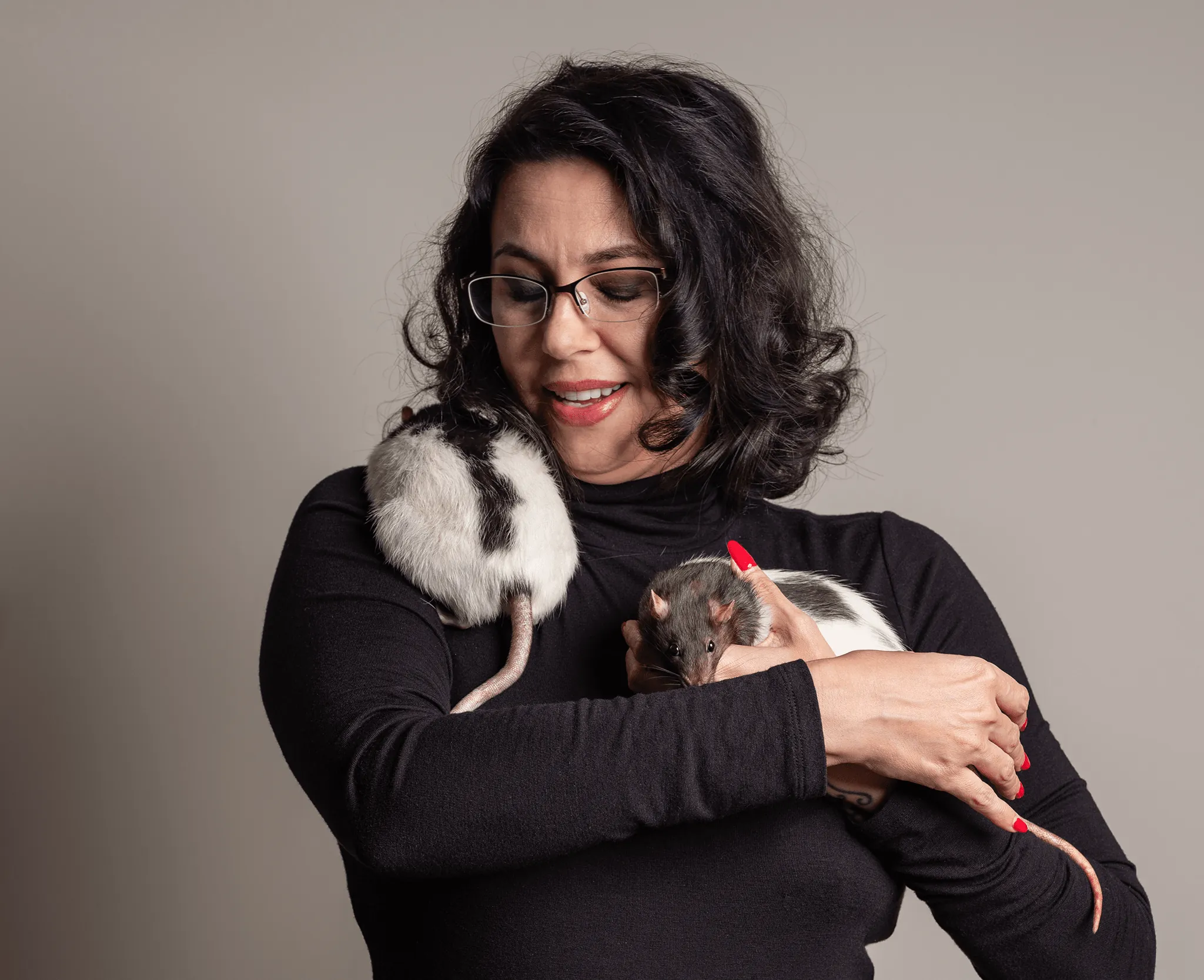 photo of brunette woman photographer holding two rats trying to escape