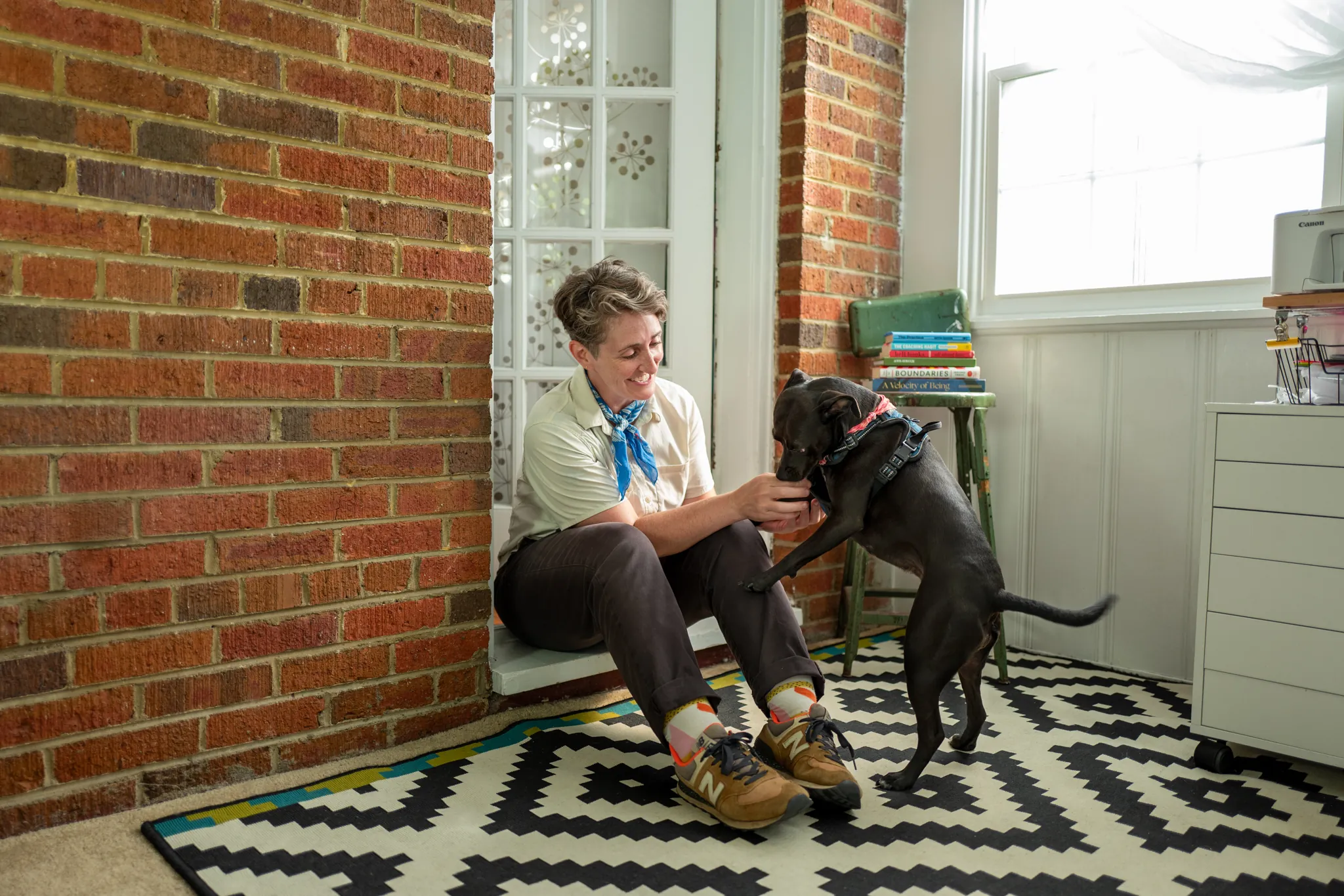 richmond va woman plays with her dog sitting on a stoop