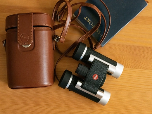 color leica binoculars on wooden table